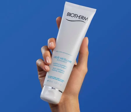 Biotherm Exfoliator in hand on blue background