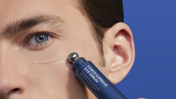 man applying eye serum around his eye