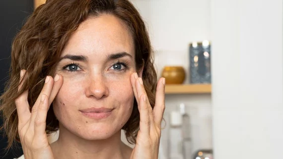 Femme qui applique du retinol autour des yeux