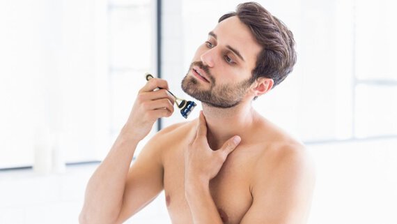Man shaves the contours of his 5-day beard