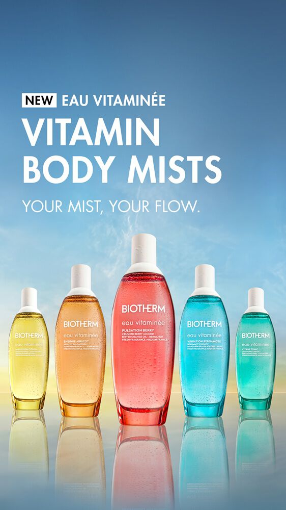 Five colorful Biotherm Eau Vitaminee body mist bottles lined up against a soft blue and yellow gradient background, with the text: “NEW Eau Vitaminee – Vitamin Body Mists. Your mist, your flow.”