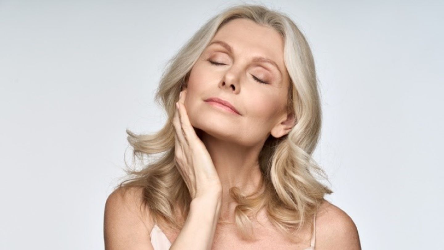 mature woman touching her face