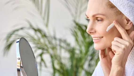 Woman in her 40s creams her face