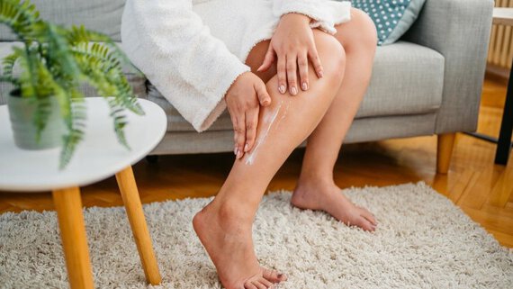 Woman over 40 applies body cream